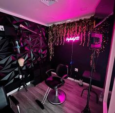 the room is decorated in black and purple with neon lights hanging from the ceiling above it