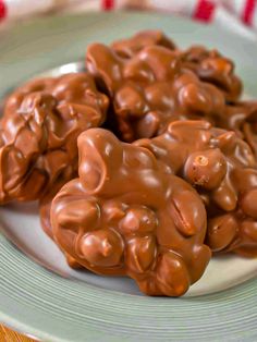 three chocolate teddy bears sitting on top of a white and green plate with silver trim