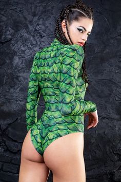 If you're looking for an exotic, tropical themed fit, the Basilisk Bodysuit will get the job done! This piece is made from a high quality stretchy and breathable Lycra fabric, printed with exceptional graphics as alwayz.The design features a body con fit with a cheeky cut, padded shoulders, long sleeves with thumbholes Green Fitted Bodysuit For Swimming, Fitted Green Tropical Bodysuit, Fitted Tropical Green Bodysuit, Tropical Printed Fitted Bodysuit, Fitted Printed Bodysuit For Swimming, Fitted Tropical Print Bodysuit, Fitted Green Printed Swimwear, Green Printed Fitted Bodysuit, Fitted Green Printed Bodysuit