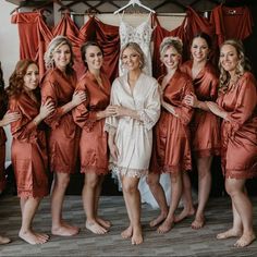 a group of women standing next to each other in front of red robes and dresses