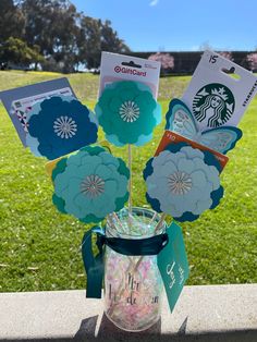 the starbucks cup is decorated with paper flowers and has cards attached to it that say starbucks