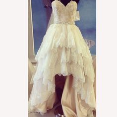 three wedding gowns on display in front of a mirror