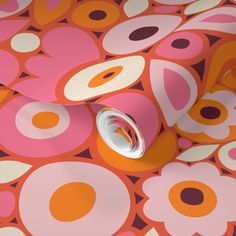 an orange and pink flower wallpaper with circles on the side, next to a roll of tape