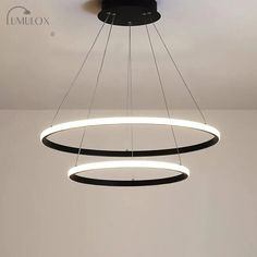 two circular lights hanging from the ceiling in a room with white walls and flooring