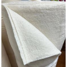 a white blanket folded on top of a bed