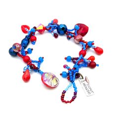 "This superbright blue and red bracelet combines vintage and newer glass, crystal and plastic baubles to create a unique piece for your look :) One of a kind, this piece is created using a mix of bright red and bright blue vintage and newer elements and is finished with one of my favorite vintage AB flash red glass buttons. Made to fit wrists measuring 7\" or smaller." Party Bracelets With Colorful Czech Glass Beads, Bohemian Glass Beaded Bracelets For Parties, Red Bracelets With Large Beads For Party, Vibrant Red Bracelets For Gift, Red Large Beads Bracelets For Party, Handmade Red Beaded Bracelets In Novelty Style, Adjustable Eclectic Red Jewelry, Red Glass Beaded Bracelets, Red Czech Glass Beaded Bracelets With Colorful Beads