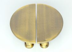 two round brass knobs on a white background, one is facing the opposite direction