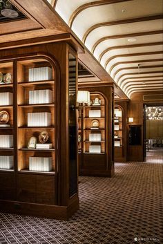 a room filled with lots of wooden bookshelves