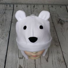 "Baby and Kids Polar Bear Fleece Hat This is a polar bear hat made from white fleece. It features felt eyes, felt nose, and fleece ears. Hat Sizes: Baby: Approx. 20\" around Child: Approx. 22\" around Youth: Approx. 23 1/2\" around Hat shown is a child size on a 18 1/2\" (47cm) head. Care: Machine wash on cool or warm; dry on low. Turnaround time is 1-3 business days. Standard Shipping is usps first class (3-5 business days). Upgrade to priority (2-3 day) and priority express (1-2 day) is availa Playful White Beanie One Size Fits Most, Adjustable Warm White Bonnet, Playful White Beanie One Size, Playful Warm White Hat, White Warm Beanie Bonnet, Playful White Bonnet For Winter, Adjustable Warm White Hat, Playful White Cap Beanie, Playful White Beanie For Winter