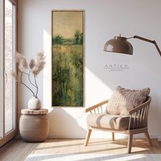 a chair sitting in front of a window next to a painting on the wall and a lamp