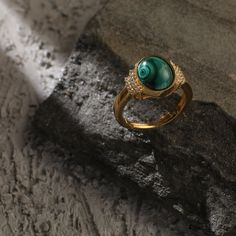 Description Inspired by the beautifully patterned Malachite gemstone, the earliest ore of copper, Tamra is eccentric, contemporary, and distinctively classy. Handcrafted on 925 hallmark silver and gold finish. This collection is curated for everyday luxury. This finger ring features a round malachite charm at the center. The side of the charm is highlighted with two lines of CZ stones to add extra glam. Striking ring to style with Paksha's unmatched delicate jewelry. Product Information Material Elegant Malachite Gemstone Ring, Fine Jewelry With Round Malachite, Fine Jewelry Malachite Round Jewelry, Round Malachite Fine Jewelry, Elegant Malachite Ring Jewelry, Malachite Rings As Gifts, Formal Malachite Gemstone Rings, Malachite Rings Gift, Luxury Malachite Jewelry