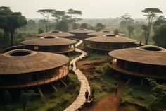 a group of people standing on top of a lush green field next to wooden huts