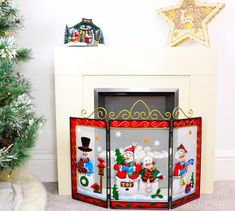 a fireplace screen decorated with snowmen and christmas decorations, in front of a tree