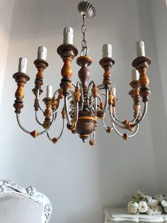 a chandelier hanging from the ceiling in a room with white walls and furniture