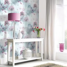 a white table sitting in front of a window next to a pink lamp