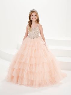 Your sweet girl will light up the room in this beaded long sleeveless dress with A-line ruffled tulle skirt by Tiffany Princess 13754. This sleeveless gown features a V-neckline with beaded embellishments, floor length A-line tulle skirt with tiered ruffles, sweep train, and a lace-up back. House of Wu Tiffany Princess Collection Spring 2024 Style Number: 13754 Fabric: Beading/Tulle Please note: There may be a loss of glitter while wearing this dress due to the nature of the fabric Colors: Blush Princess Style Sleeveless Embellished Pageant Dress, Elegant Pageant Dress With Tulle Ball Gown, Elegant Pageant Ball Gown With Tulle Skirt, Elegant Tulle Ball Gown Pageant Dress, Princess Style Sleeveless Dress For Debutante Ball, Princess Style Sleeveless Debutante Ball Dresses, Princess Style Sleeveless Pageant Dress With Fitted Bodice, Sleeveless Tulle Pageant Dress With Fitted Bodice, Princess Sleeveless Ball Gown For Pageant