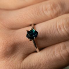 a woman's hand with a ring that has a blue stone on the middle