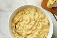 a bowl of macaroni and cheese with a slice of bread