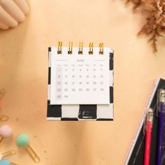 a desk with a calendar, pencils and other office supplies on top of it