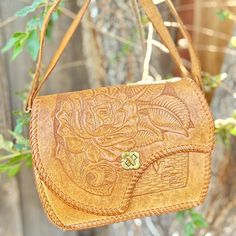 Tan tooled leather vintage shoulder bag. Exterior is in great vintage condition. Interior is worn with peeling, ripped pocket, stains.  Clasp closure 1 intact inner pouch pocket  9 1/2" x 7" About 3 1/2" deep 6" handle drop Smoke-free and golden retriever-friendly household. Vintage Embossed Satchel For Everyday Use, Vintage Embossed Shoulder Bag For Daily Use, Vintage Embossed Satchel Bag, Vintage Leather Embossed Shoulder Bag, Vintage Leather Shoulder Bag With Embossed Details, Vintage Embossed Leather Shoulder Bag, Vintage Distressed Brown Shoulder Bag For Travel, Vintage Brown Bag With Cell Phone Pocket, Vintage Brown Embossed Shoulder Bag