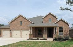 a large brick house with two garages in the front yard