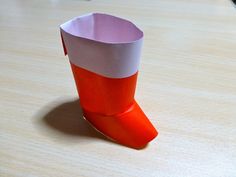 an orange and white cup sitting on top of a wooden table