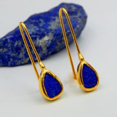 Lapis Lazuli Rough Gemstone Earrings. Minimalist Drop Earrings made out of 18 karat Gold plated Sterling Silver. 100% Handmade Jewellery with best quality stones. LAPIS LAZULI: The sweet sounding name of this gem is composed of 'Lapis', the Latin word for stone, and 'Azula', which comes from the Arabic and means 'blue'. Historians believe the link between humans and lapis lazuli stretches back more than 6,500 years. The gem was treasured by the ancient civilizations of Mesopotamia, Egypt, China, Teardrop Gemstone Linear Earrings As Gift, Teardrop Gemstone Linear Earrings For Gift, Minimalist Natural Stone Teardrop Earrings, Gold Lapis Lazuli Earrings As Gift, Gold Earrings With Natural Lapis Lazuli Stones, Elegant Lapis Lazuli Earrings With Natural Stones, Elegant Lapis Lazuli Earrings, Round Lapis Lazuli Gemstone Earrings, Lapis Jewelry