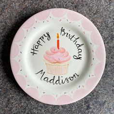 a plate with a cupcake on it that says happy birthday madison and a lit candle