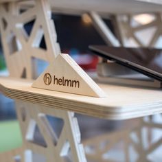 a close up of a wooden table with a laptop on it and the word heimm