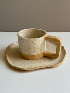 a white cup and saucer sitting on top of a wooden plate with a handle