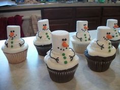 cupcakes made to look like snowmen with frosting on them