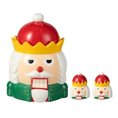 a ceramic nutcracker with two smaller ones in the foreground, one wearing a crown