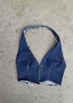 Denim, we love it. The Phobya Halter, in original indigo denim! - just in time for summer. Hand crafted from top-quality sustainable denim and completely unique. Finished with the statement Safety Pin Closure and adjustable neck strap.  This top is designed to be uniquely worn, adjusting the pins to the wearer. - Safety Pin closure - Handmade  - One piece halter-neck and waistcoat design - Fitted waist - Cropped length - Pre-washed   - Sustainable dead-stock denim  - Available in black and blue Fitted Pre-washed Blue Jeans, Fitted Cutoff Denim Jeans, Fitted Dark Wash Cutoff Jeans, Fitted Cutoff Denim Blue Jeans, Fitted Denim Blue Cutoff Jeans, Indigo Cotton Jeans For Summer, Fitted Cotton Cutoff Top, Fitted Washed Blue Cutoff Jeans, Fitted Washed Indigo Jeans