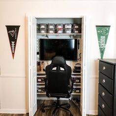 an office chair sits in front of a tv and shelves filled with items on the wall