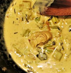 a wooden spoon in a pot filled with soup