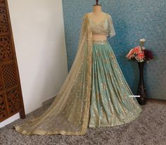 Made to Order/Measurement/Custom Order Lehenga - Color : Sea Green - Fabric :  Georgette - Fully Flared embroidered georgette lehenga skirt - Sea Green embroidered georgette blouse - Gold Net embroidered dupatta with border - Drawstring closure with designer Tassels - Can can attached PLEASE NOTE: BUYERS ARE RESPONSIBLE FOR ANY CUSTOMS AND IMPORT TAXES THAT MAY APPLY. Fabric Care : Dry Clean Only Disclaimer: Please note the photographs are taken by mobile camera in sunlight The actual color of the product might slightly differ due to exposure of light or monitor's display Shipping: This is made to order product. We customize the pattern of the dress to suit your style and fitting. Once you place the order we will provide you with a template for measurements (to be taken in inches). It usua Gold Sharara With Dupatta For Ceremonies, Gold Anarkali Sharara For Ceremony, Bollywood Style Gold Gown For Ceremony, Gold Bollywood Gown For Ceremony, Festive Green Lehenga For Ceremony, Diwali Green Sets With Gold Embroidery, Festive Green Sets With Gold Embroidery, Green Sets With Gold Embroidery In Traditional Drape, Green Dupatta With Gold Embroidery For Wedding