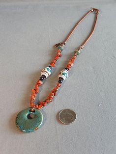 This casual, boho style necklace features beautiful earthy colors of the southwest. The round pendant is made from spatter glaze porcelain and is soft teal in color. Also features hand painted Native American clay beads, and Red Jasper gemstone chip beads, and a cute copper thunderbird charm, finished with brown leather cord and an antique copper plated toggle clasp. The necklace is 27 inches long. the round pendant is 1 inch. If you love the western vibe, this necklace is for you ! American Clay, Pearl Bib Necklace, Casual Boho Style, Boho Style Necklaces, Porcelain Beads, Southwest Style, Chip Beads, Freshwater Cultured Pearls, Pony Beads