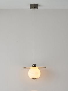 a light fixture hanging from the ceiling in a room with white walls and flooring