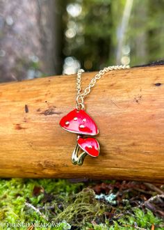 This cottage core mushroom necklace features two red little amanita muscaria mushrooms on a gold colored chain. Add it to your cottage core wardrobe or give it as a gift to any nature loving friend. The mushroom pendant measures approx. 1″ tall by 3/4″ wide and hangs from an adjustable 18″-20″ chain. Red Mushroom Design Jewelry Gift, Mushroom Shaped Necklace For Gifts, Mushroom Design Necklace As Gift, Mushroom Design Necklace For Gifts, Mushroom Design Necklace Gift, Mushroom Design Necklace For Gift, Whimsical Mushroom Print Jewelry Gift, Cottage Core Wardrobe, Cottage Core Mushroom