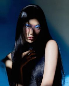 a woman with long black hair and bright blue makeup is posing for the cover of marie claire magazine