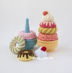 crocheted toys are stacked on top of each other in different colors and sizes