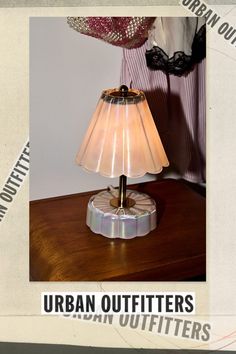 a lamp that is sitting on top of a wooden table with the words urban outfitters written below it