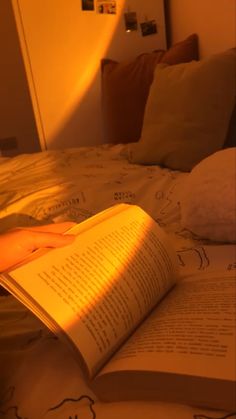 an open book sitting on top of a bed