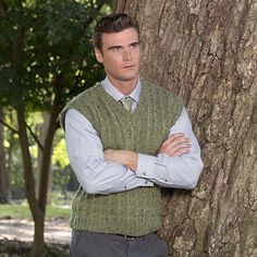 a man standing in front of a tree with his arms crossed