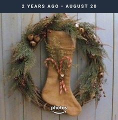 a christmas stocking hanging on the side of a door with holly wreath and bells