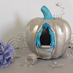 there is a silver pumpkin with a blue scarf on it