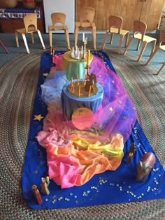 a birthday cake sitting on top of a blue table cloth covered in colorful icing