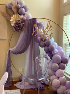 a purple and gold balloon arch with the word bride on it in front of a mirror