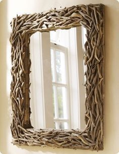 a mirror made out of branches hanging on the wall