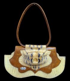 a brown and white handbag with an animal head on the front, sitting against a black background